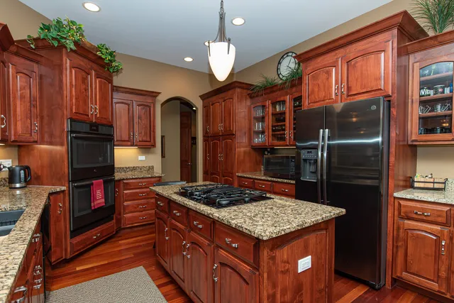 a kitchen with stainless steel appliances granite countertop a stove refrigerator and cabinets