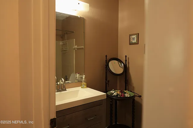 a bathroom with a sink vanity and a mirror