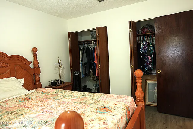 a bedroom with filled bed and a mirror