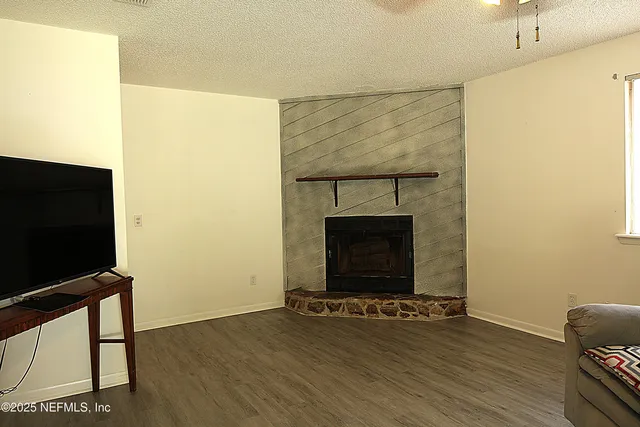 a living room with a fireplace a flat screen tv and a table