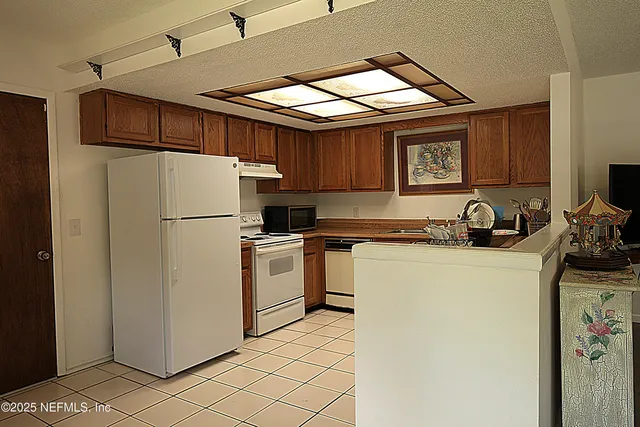 a kitchen with a refrigerator and a stove top oven