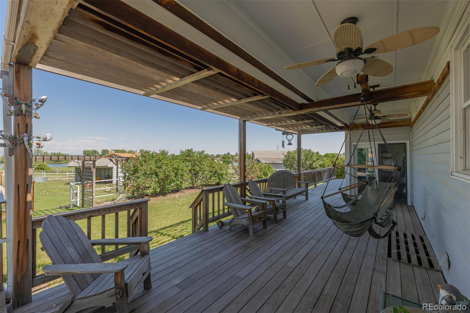 14447 Madison Street Thornton, CO 80602 - Photo 19 of 37 a view of a balcony with chairs and wooden floor