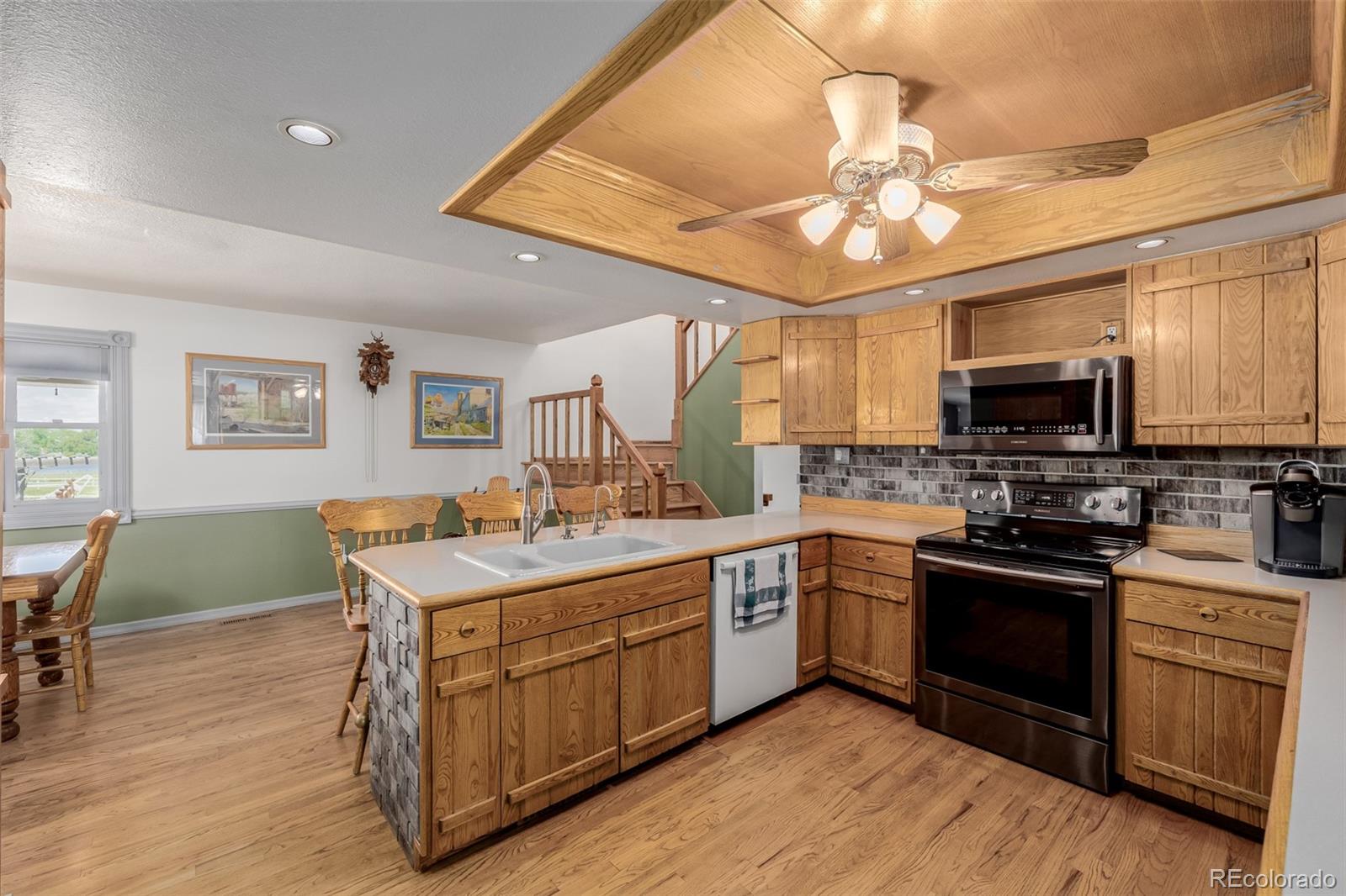 14447 Madison Street Thornton, CO 80602 - Photo 31 of 37 a kitchen with a sink stove and microwave