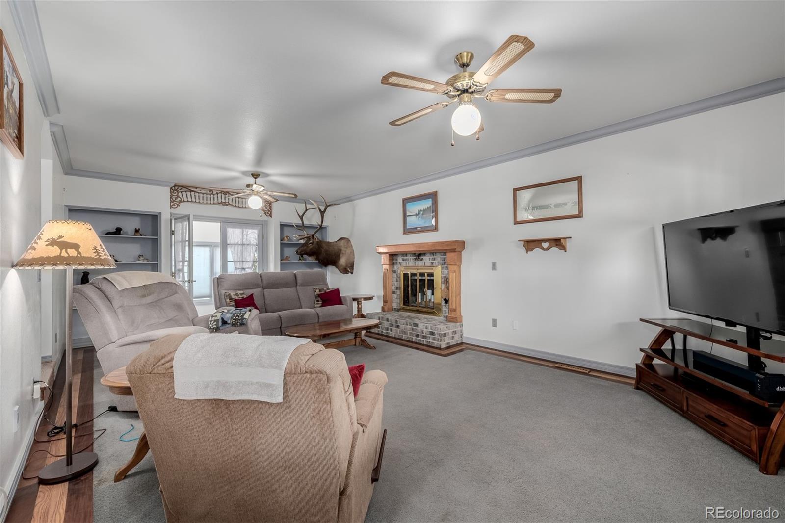 14447 Madison Street Thornton, CO 80602 - Photo 33 of 37 a living room with furniture a window and a flat screen tv