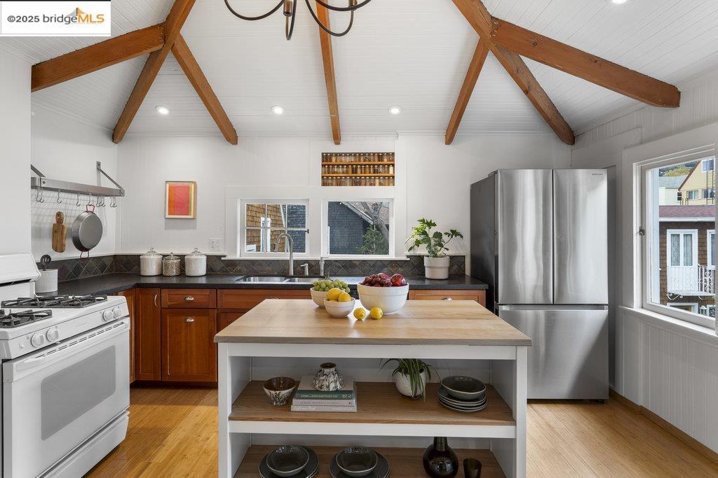 2587 Piedmont Avenue, Unit 3 Berkeley, CA 94704 - Photo 13 of 33 a kitchen with stainless steel appliances a stove a refrigerator a sink dishwasher and wooden cabinets with wooden floor