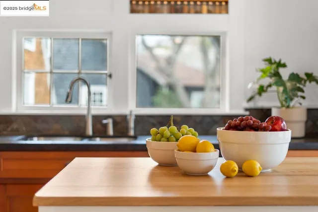 a kitchen with stainless steel appliances granite countertop a dining table chairs and chandelier