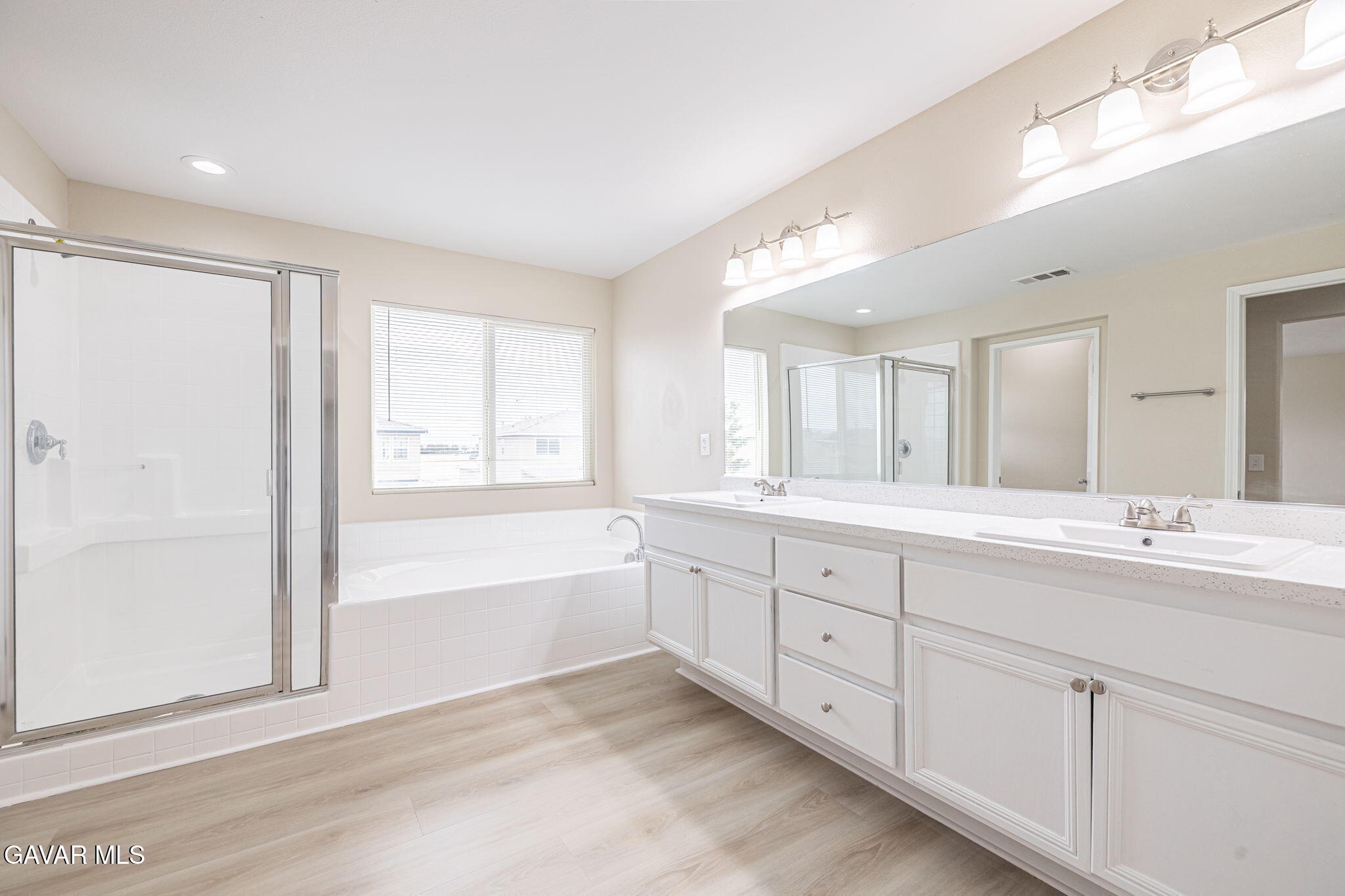 2834 Allessandra Court Lancaster, CA 93535 - Photo 35 of 51 a spacious bathroom with double vanity a mirror and a bathtub