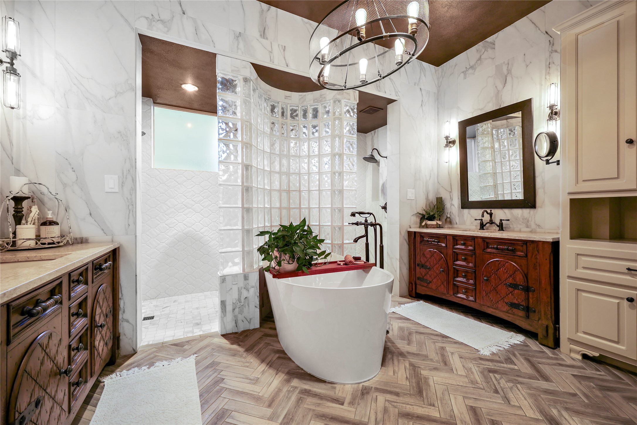 17501 Navigation Lane Lago Vista, TX 78645 - Photo 24 of 40 This Primary bathroom features herringbone-patterned flooring, a freestanding tub, and a shower enclosed by glass blocks