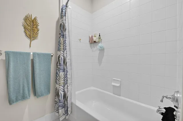 a bathroom with a granite countertop sink mirror and a bath tub