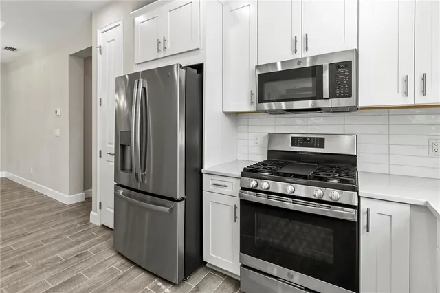 a kitchen with stainless steel appliances a refrigerator microwave and stove top oven