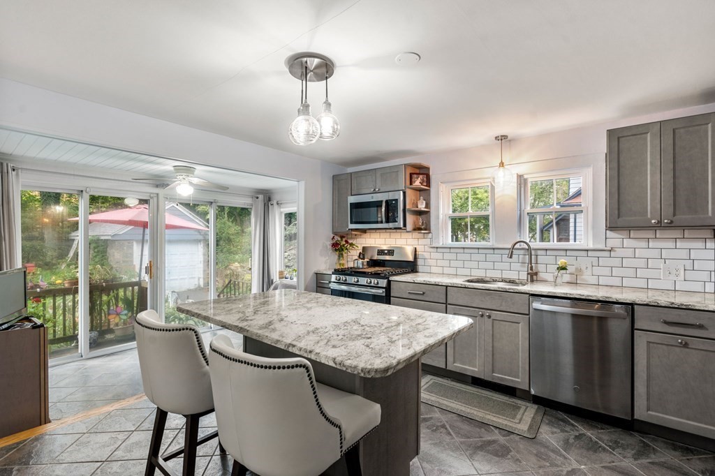 17 Centre Lane Milton, MA 02186 - Photo 6 of 26 a kitchen with granite countertop a sink and dishwasher a oven with wooden cabinets