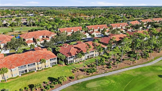 an aerial view of residential houses with outdoor space and trees