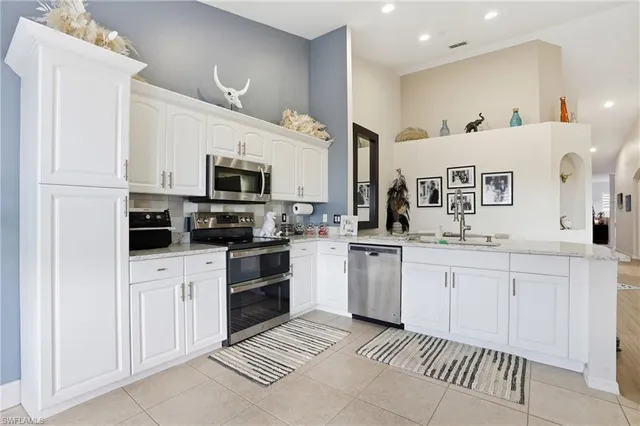 a kitchen with granite countertop white cabinets and stainless steel appliances