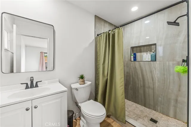 a bathroom with a sink a toilet and shower