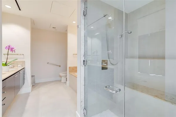 a bathroom with a granite countertop sink a toilet and shower