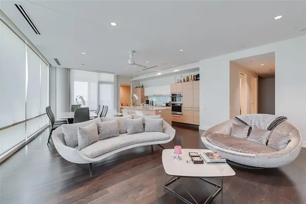 a living room with furniture and a dining table with wooden floor