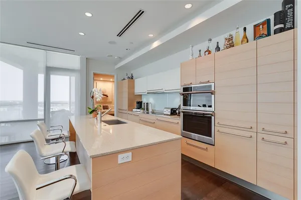 a kitchen with a sink a kitchen island and stainless steel appliances