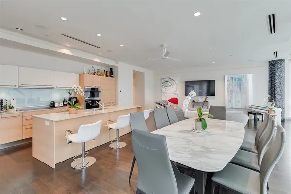 a kitchen with stainless steel appliances granite countertop a table chairs and a refrigerator