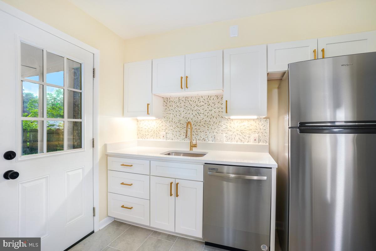 804 Gregorio Drive Silver Spring, MD 20901 - Photo 14 of 33 a kitchen with a refrigerator sink and cabinets