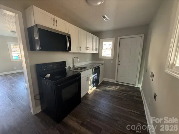 a bathroom with a granite countertop sink a toilet and shower
