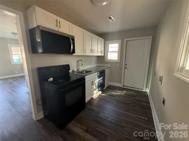 a bathroom with a granite countertop sink a toilet and shower