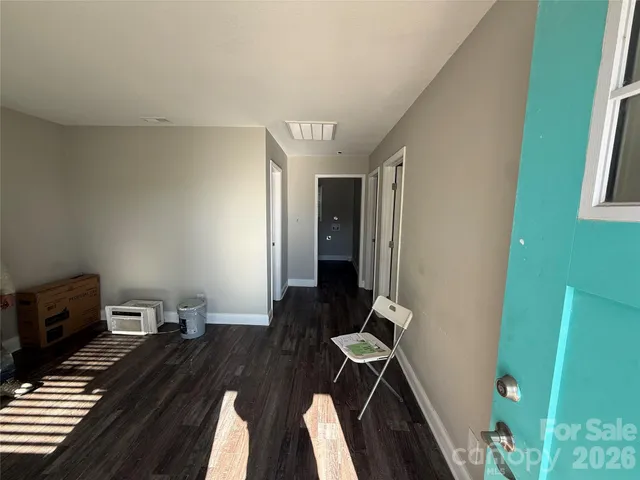 a view of an empty room with a window and a dresser