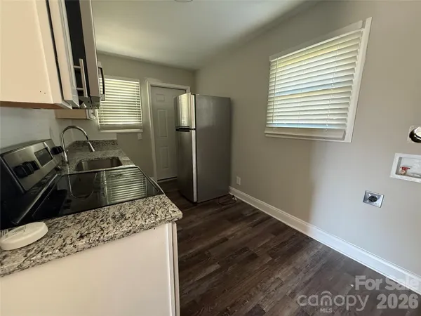 a kitchen with stainless steel appliances a stove a sink a microwave a refrigerator a window and cabinets