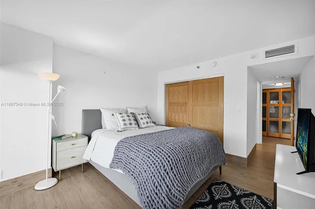 a bedroom with a bed and wooden floor