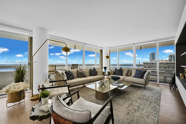 a living room with furniture kitchen view and a wooden floor