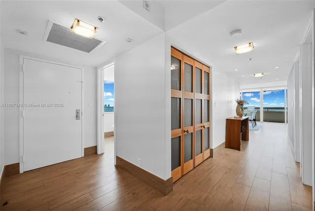 a view of a hallway with wooden floor and windows