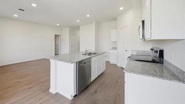 a kitchen with stainless steel appliances granite countertop a sink stove and cabinets