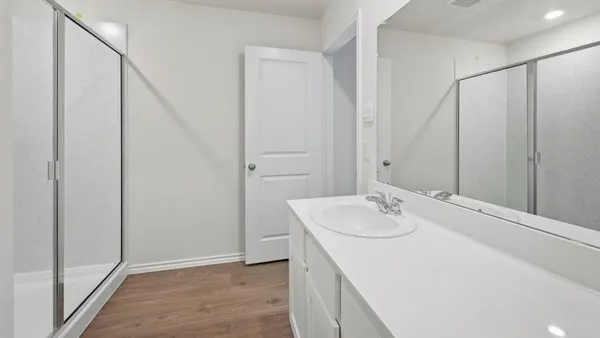 a bathroom with a sink vanity and shower