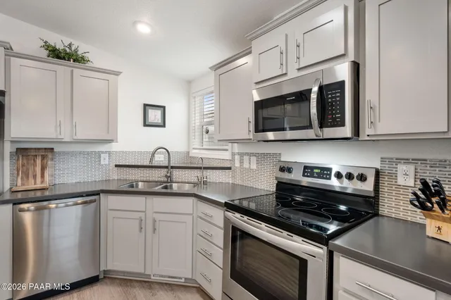 a kitchen with cabinets stainless steel appliances and sink