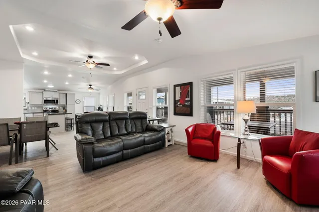 a living room with furniture ceiling fan and a window
