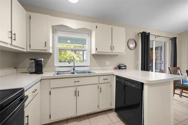 a kitchen with cabinets appliances a sink and a window