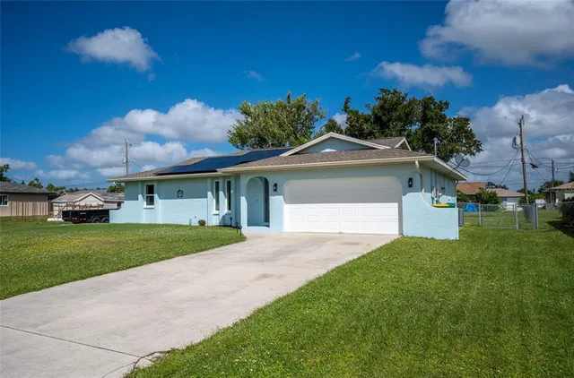 a view of a house with a yard and a large tree