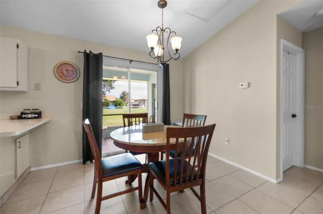 a dining room with furniture a chandelier and window