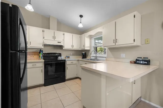a kitchen with kitchen island white cabinets appliances and a window