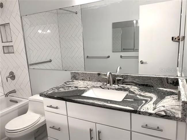2451 Canadian Way, Unit 59 Clearwater, FL 33763 - Photo 14 of 58 a bathroom with a granite countertop sink a toilet and mirror