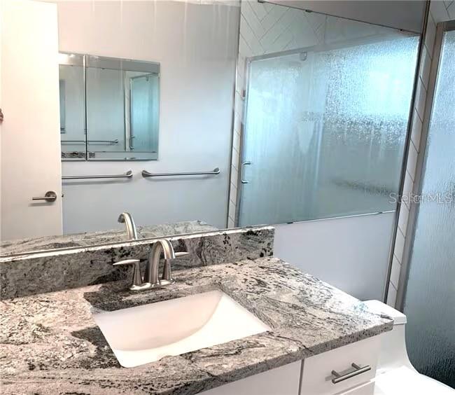 2451 Canadian Way, Unit 59 Clearwater, FL 33763 - Photo 18 of 58 a bathroom with a granite countertop sink and a mirror