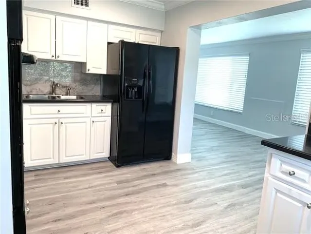 a kitchen with granite countertop a refrigerator sink and microwave
