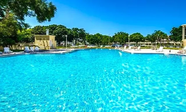 a view of a swimming pool with a patio and a yard