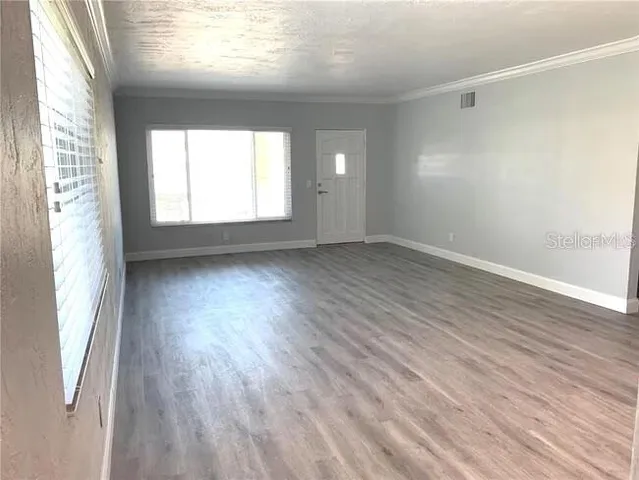 a view of an empty room with wooden floor