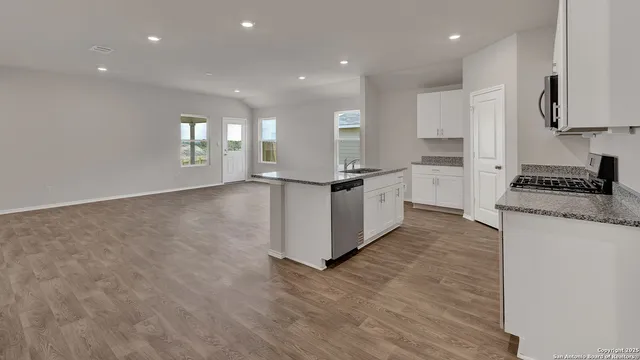 a kitchen with granite countertop a sink and a stove top oven