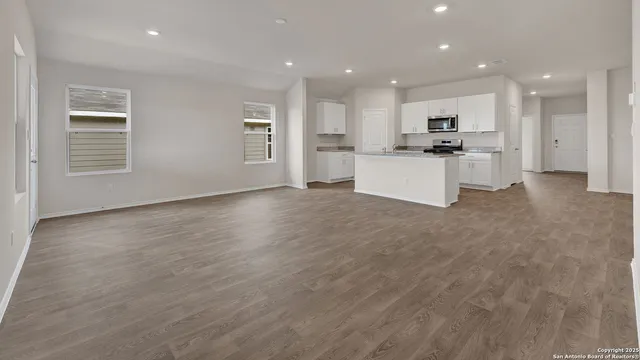 a view of kitchen with kitchen island white cabinets and stainless steel appliances
