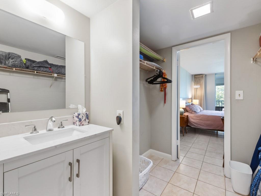 3 Bluebill Avenue, Unit 206 Naples, FL 34108 - Photo 11 of 19 a en suite bathroom with a sink a mirror and a shower