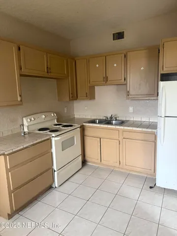 a kitchen with cabinets appliances and a sink