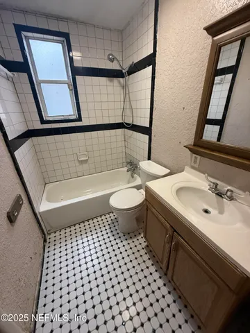 a bathroom with a sink toilet a mirror and shower