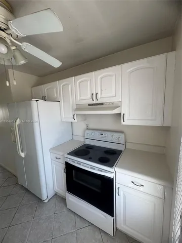 a kitchen with granite countertop white cabinets and white appliances