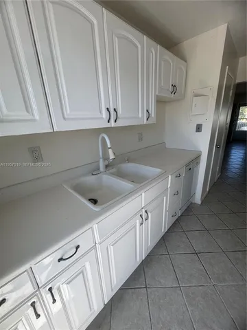a kitchen with a sink dishwasher and cabinets